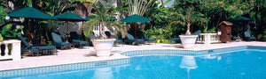 Geometric patterned glass tile on swimming pool waterline, patio furniture, and outdoor umbrellas